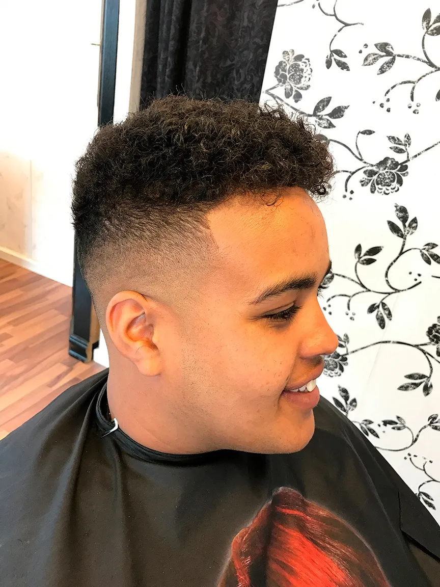 Krøllet top med mid skin fade og skarp kant ved tindingen