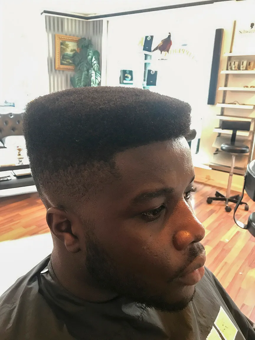 High-top afro med taper fade og skarpt optrukket panderand